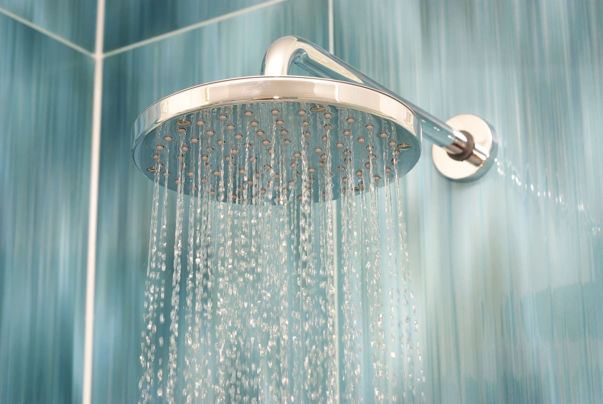 A shower head with water cascading down, creating a refreshing stream in a bright bathroom setting.